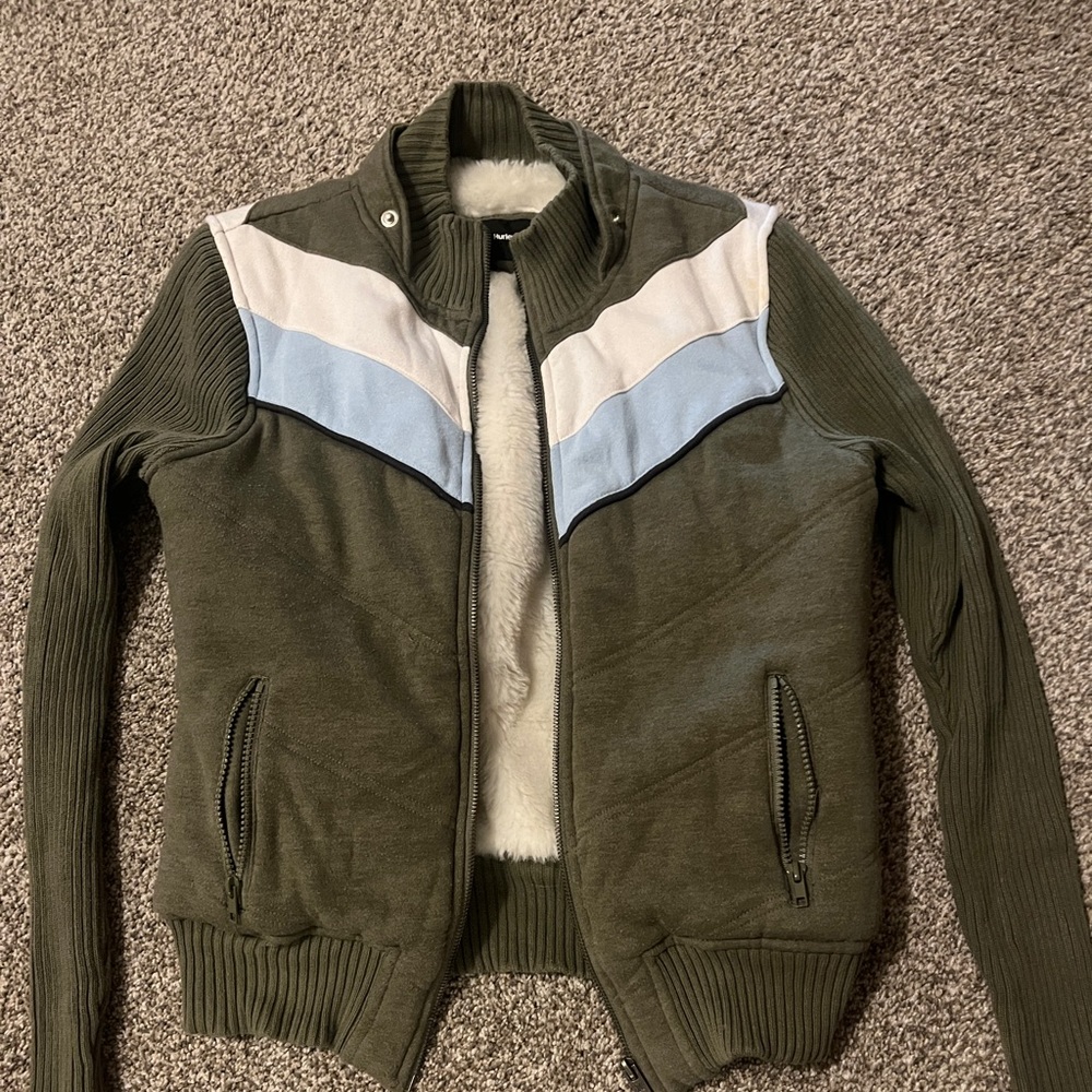 Medium sized green jacket with white and blue zig zags and a furry inside.